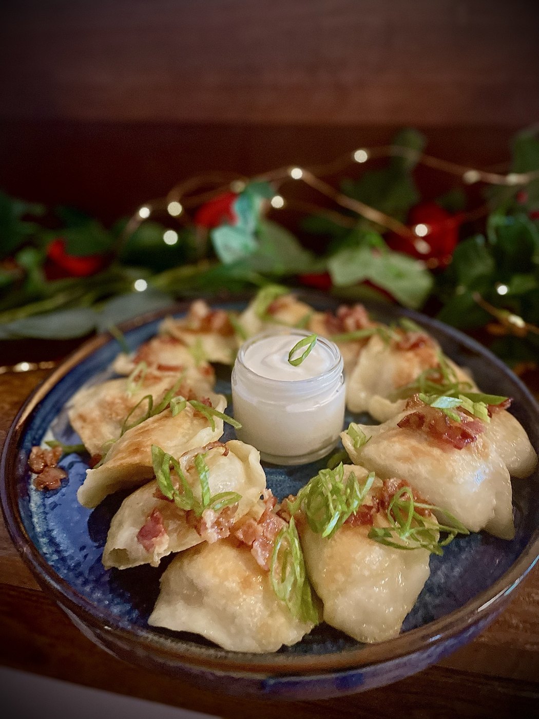 Homemade pierogi with bacon, scallions and sour cream